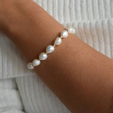 Angled view of the Aliya gold and ivory baroque pearl bracelet, showing how the pearls sit around the wrist.
