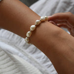 Aliya sterling silver and ivory baroque pearl bracelet worn on the wrist, with the other hand resting alongside it.