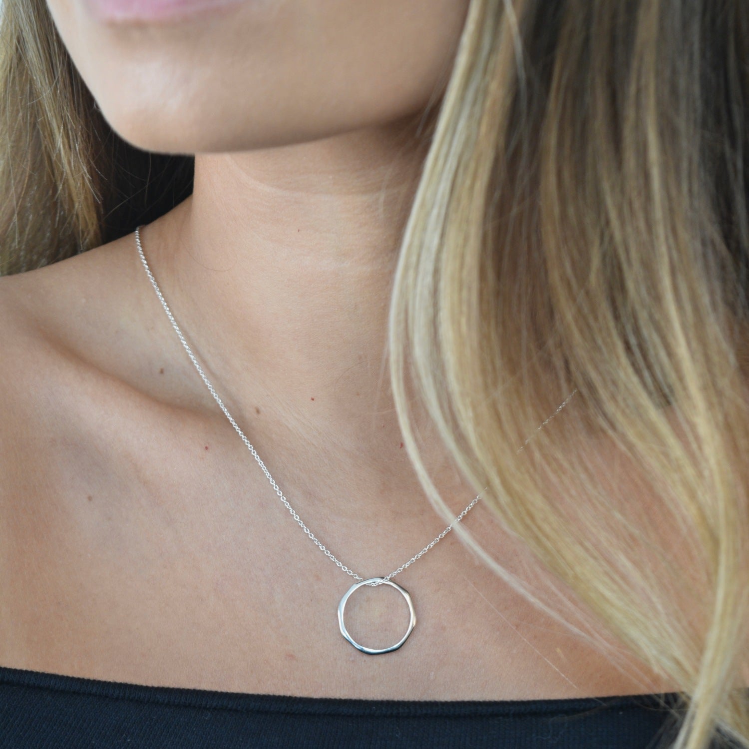 Sterling silver angled hoop pendant necklace with a modern circular pendant on a delicate chain.