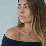 Sterling silver angled hoop pendant necklace with a modern circular pendant on a delicate chain.