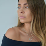 Sterling silver angled hoop pendant necklace with a modern circular pendant on a delicate chain.