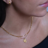 Gold Heart St Christopher Necklace worn on model in black top 
