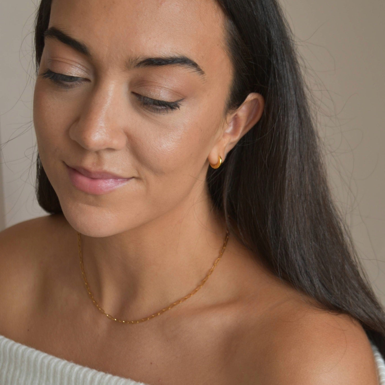 Gold vermeil paperclip chain necklace worn at the collarbone, shown on a model looking down.