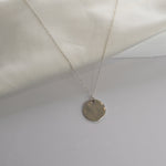 Hammered Disc Pendant Necklace with a textured circular pendant on a delicate chain.