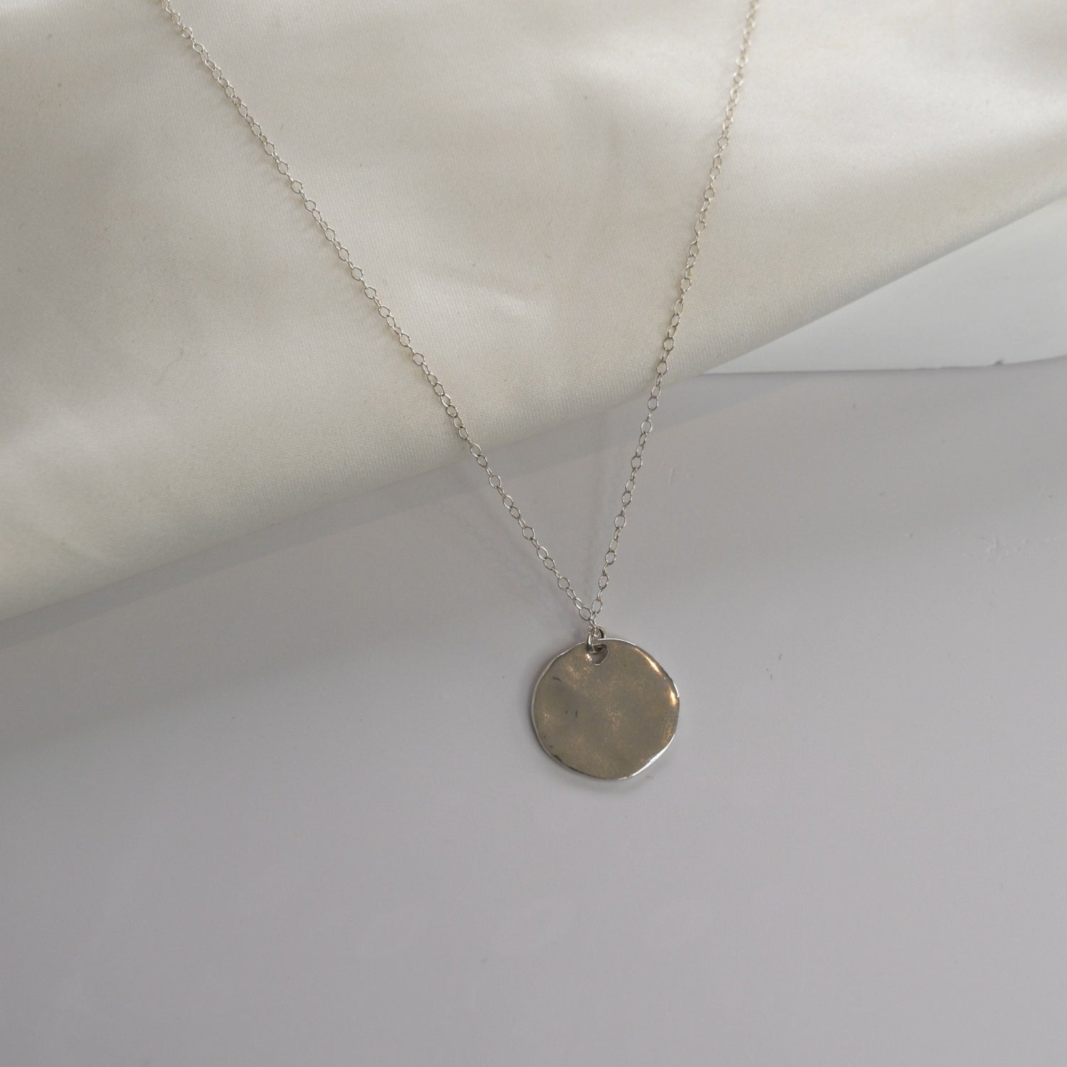 Hammered Disc Pendant Necklace with a textured circular pendant on a delicate chain.