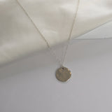 Hammered Disc Pendant Necklace with a textured circular pendant on a delicate chain.