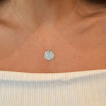 Hammered Disc Pendant Necklace with a textured circular pendant on a delicate chain.