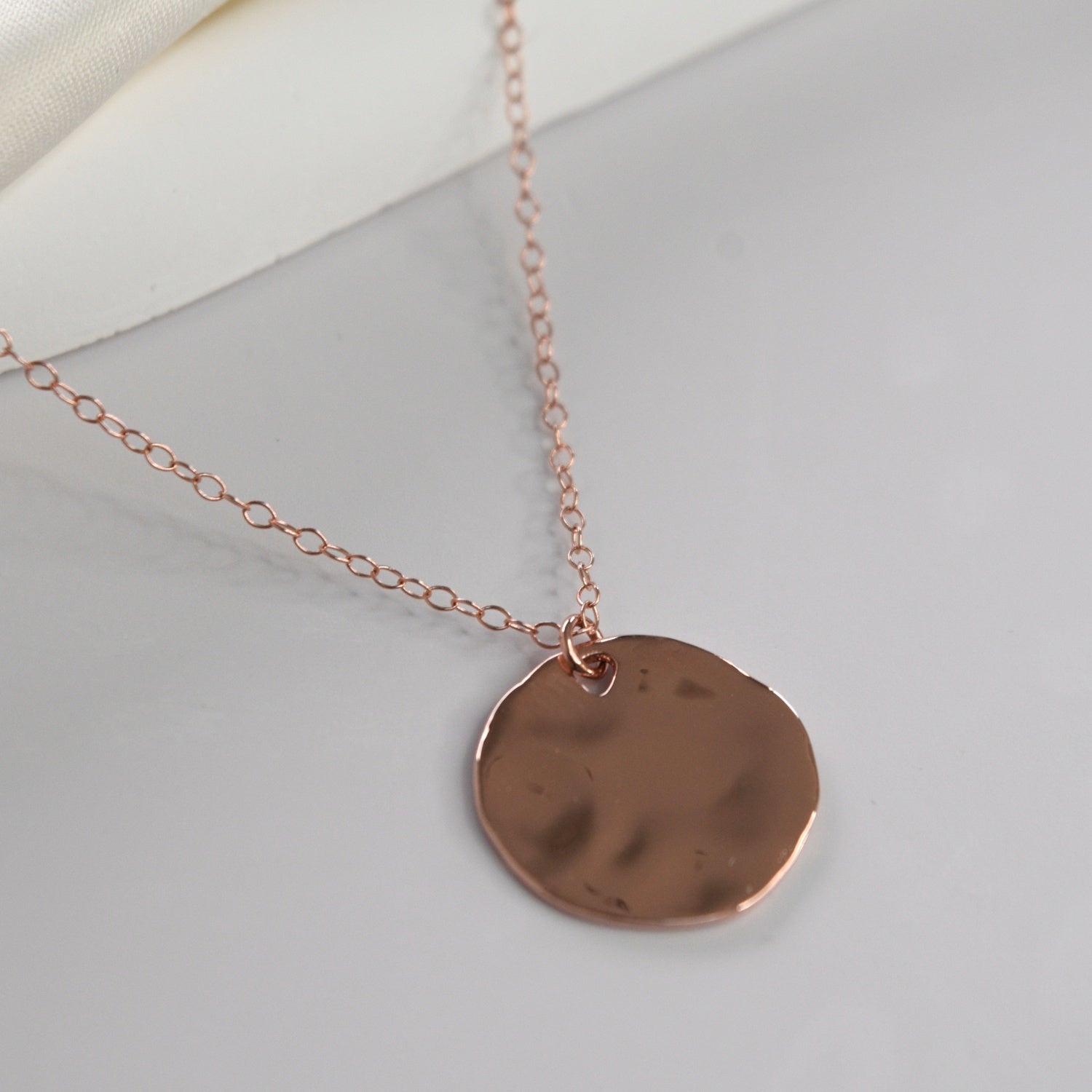 Hammered Disc Pendant Necklace with a textured circular pendant on a delicate chain.