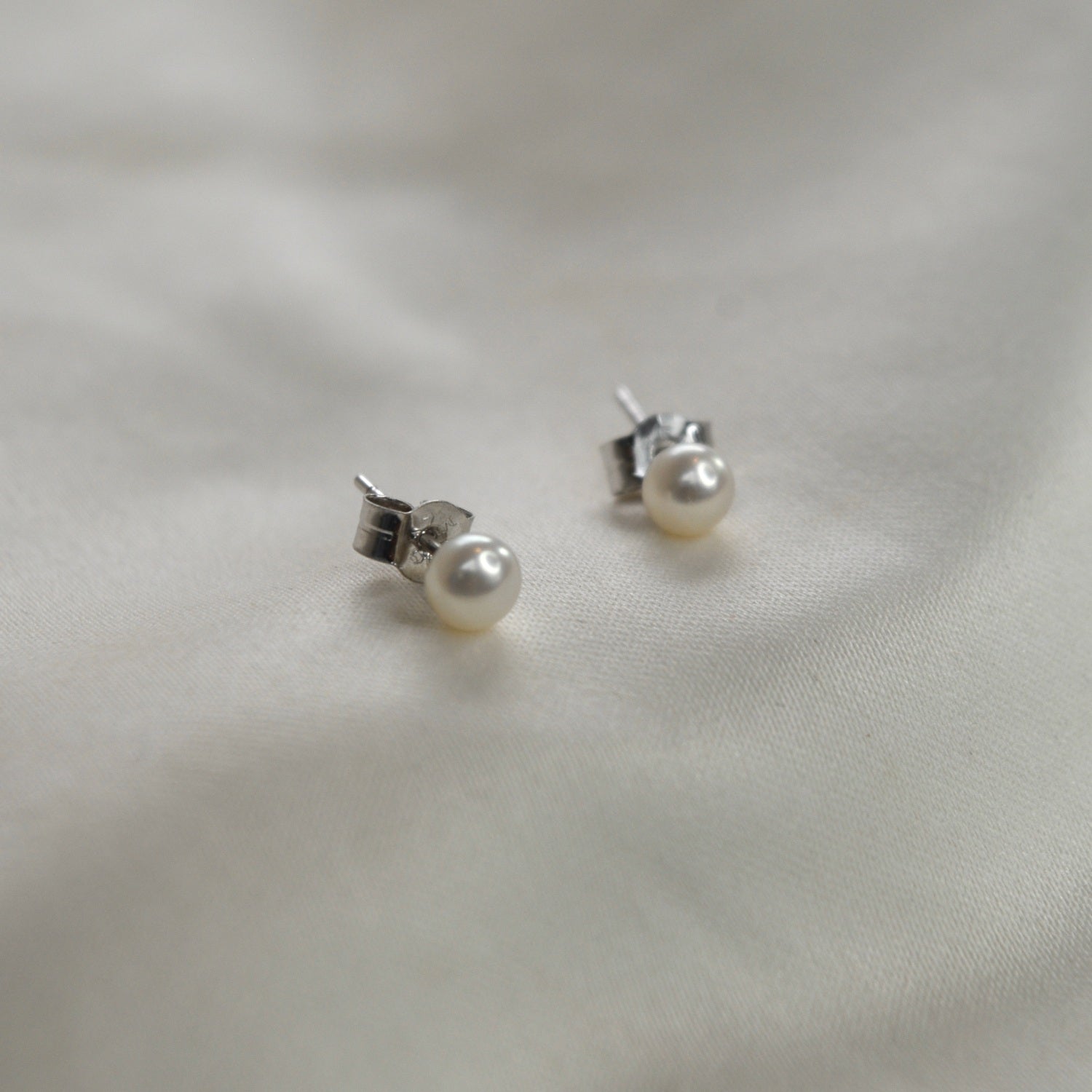 Ivory Pearl Stud Earrings featuring cultured freshwater pearls set in sterling silver.