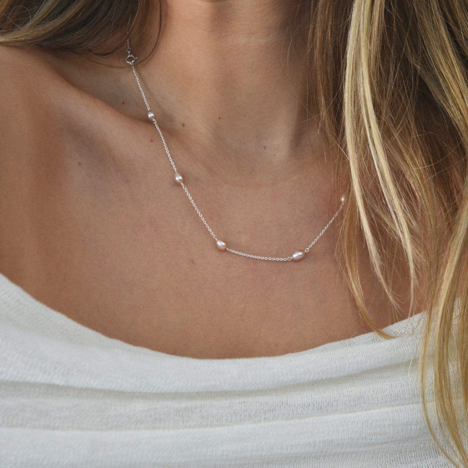 Nova Freshwater Pink Pearl Necklace featuring blush pink freshwater pearls spaced along a delicate sterling silver chain.