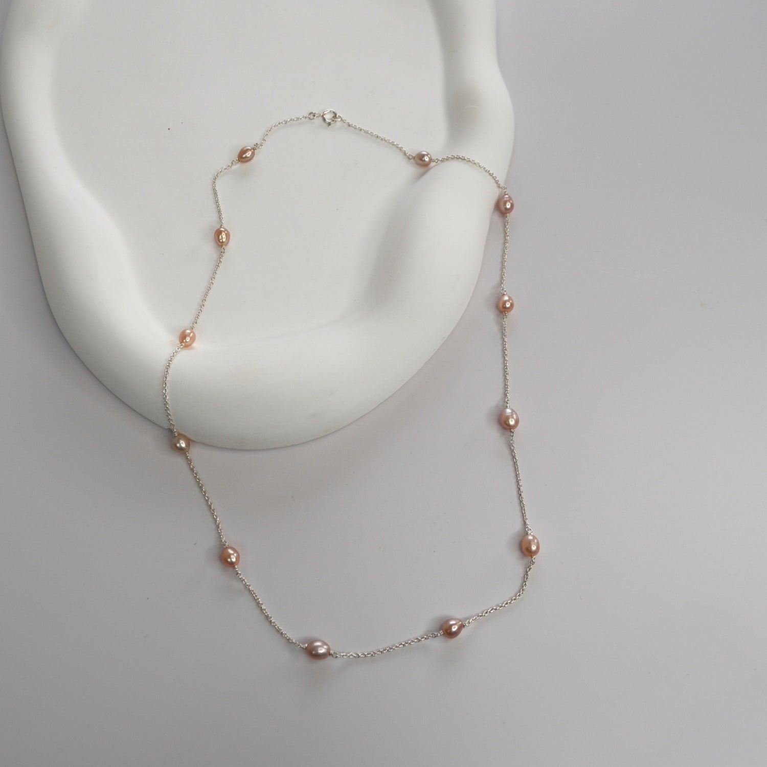 Nova Freshwater Pink Pearl Necklace featuring blush pink freshwater pearls spaced along a delicate sterling silver chain.