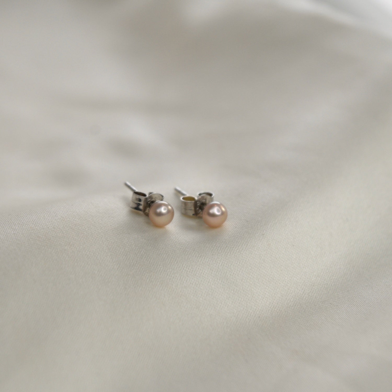 Pink Pearl Stud Earrings featuring cultured freshwater pearls set in sterling silver.
