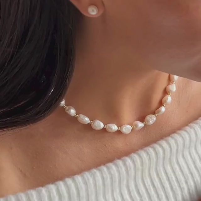 model wearing a chunky silver pearl necklace with matching pearl stud earrings 