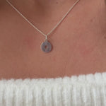 a model wearing a sterling silver compass pendant on a fine silver trace chain 