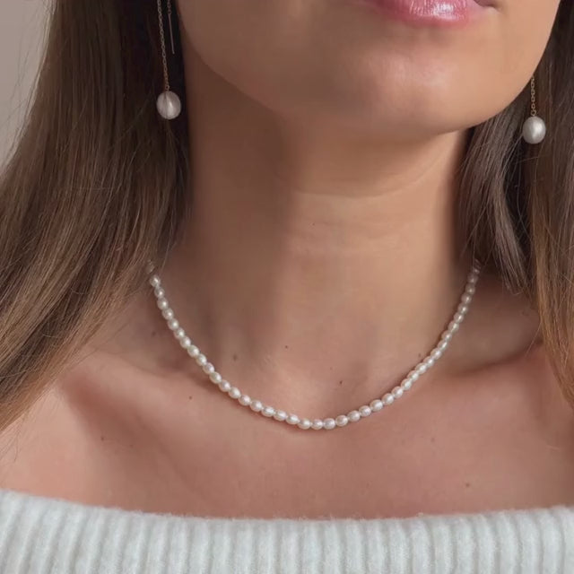 ivory seed pearl necklace on model with matching pearl earrings 