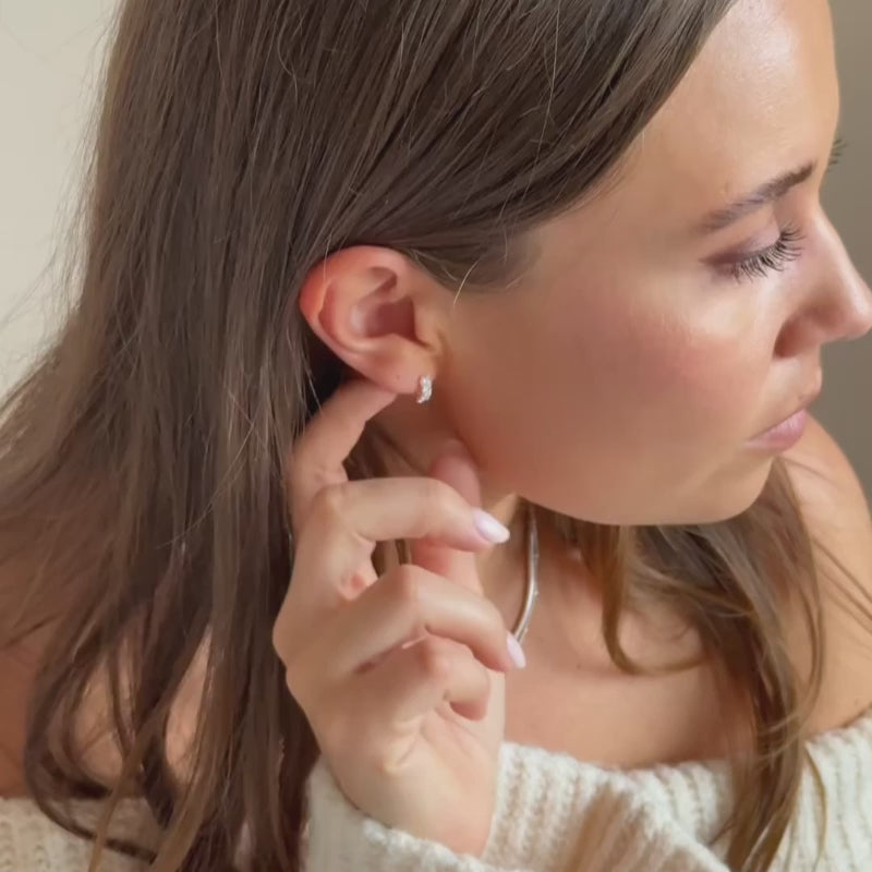 a model wearing silver CZ huggie hoop earrings 