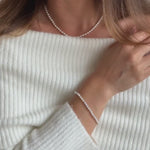 a model wearing a delicate ivory seed pearl bracelet 