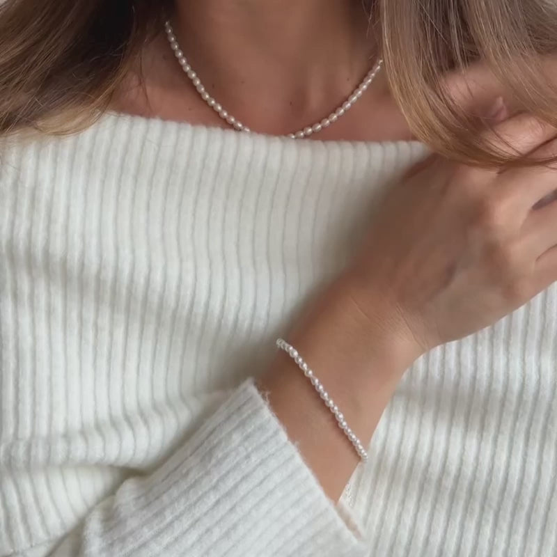 a model wearing a delicate ivory seed pearl bracelet 