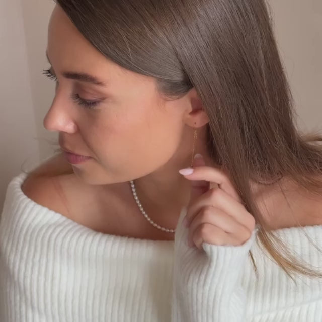 a model wearing gold vermeil pearl threader earrings 