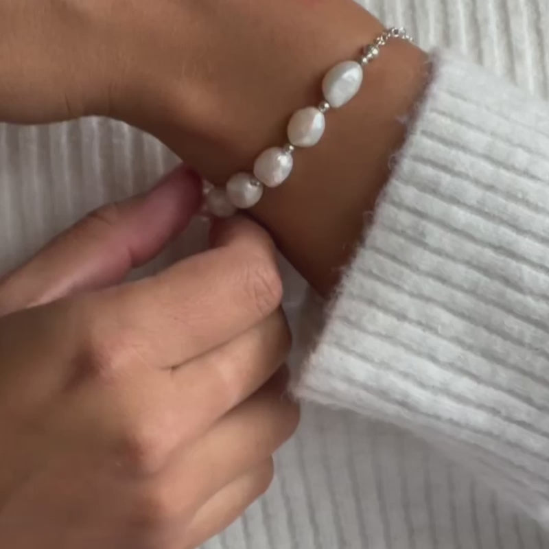 a model wearing a chunky pearl bead bracelet in silver