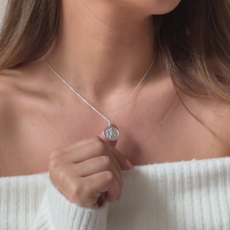 a model wearing a sterling silver st Christopher necklace on a plain trace chain 