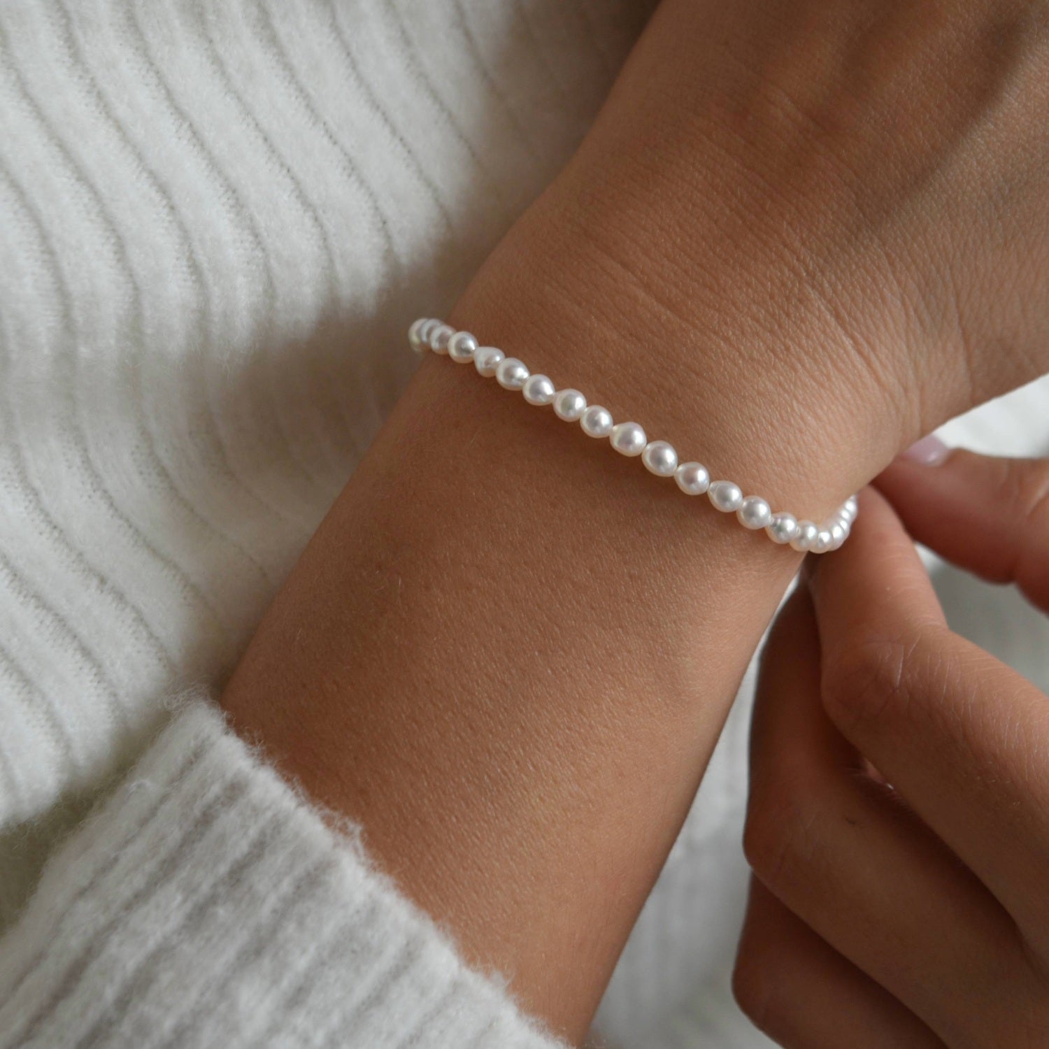 Close-up of the Riya sterling silver ivory seed pearl bracelet, showing the small pearls around the wrist.