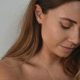 Signature Huggie Earrings with a polished finish, available in sterling silver or 18ct gold vermeil.