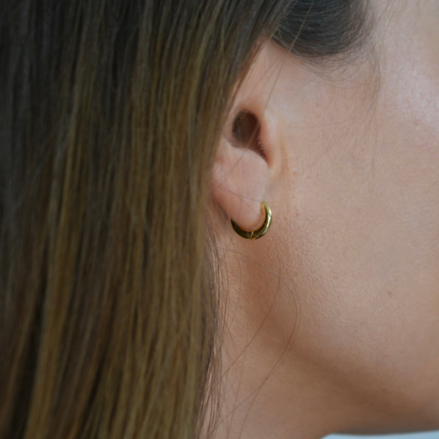 Signature Huggie Earrings with a polished finish, available in sterling silver or 18ct gold vermeil.