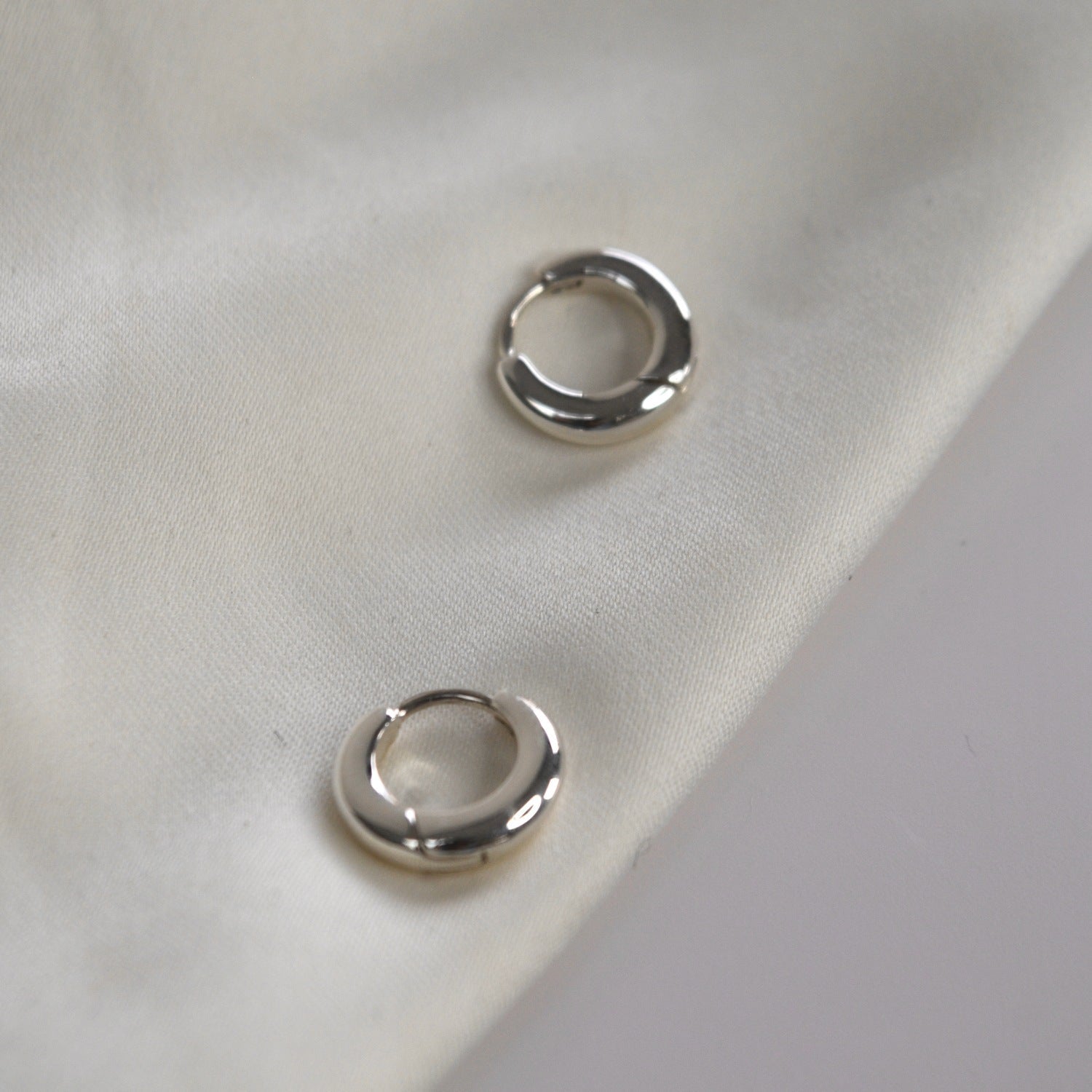 Signature Huggie Earrings with a polished finish, available in sterling silver or 18ct gold vermeil.