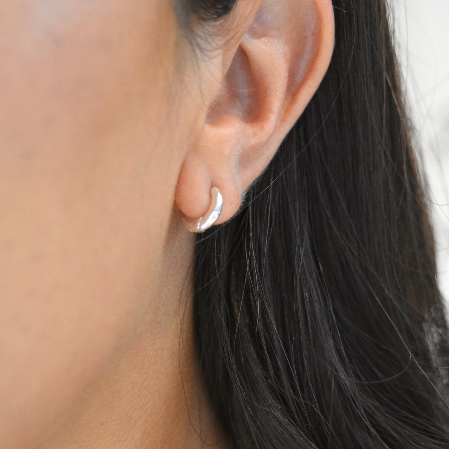 Signature Huggie Earrings with a polished finish, available in sterling silver or 18ct gold vermeil.